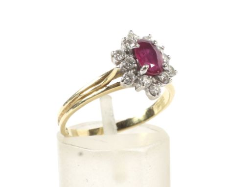 A vintage Italian 18ct gold, ruby and diamond oval cluster ring. Centred with a marquise ruby within a small round brilliant 