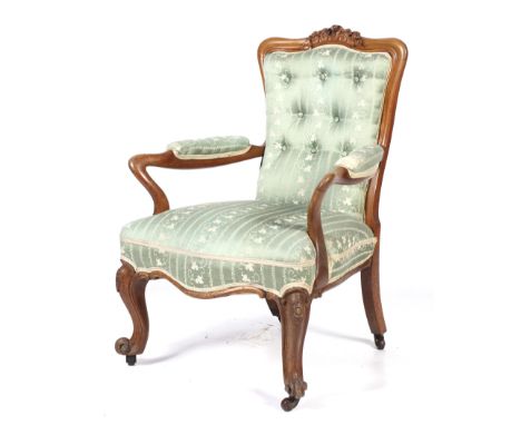 An early 20th century light oak armchair. With carved top rail and button back, upholstered pale green and cream fabric, on c