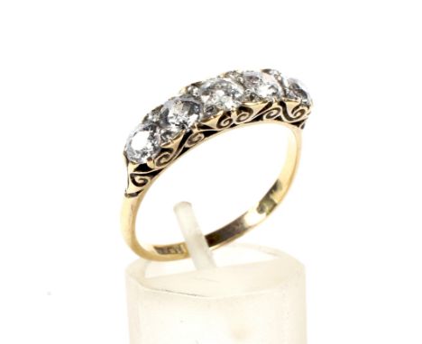 A late Victorian gold and diamond five stone carved half-hoop ring. With rose diamond points, the graduated old-cut stones ap