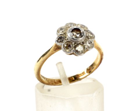 An early-mid 20th century gold and diamond 'daisy' cluster ring. Centred with an early modern round brilliant diamond approx.