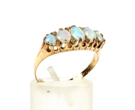 A late Victorian gold and opal five stone ring. The graduated oval-cabochon white -opals each display a pleasing play of most