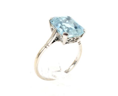 A mid-20th century platinum and aquamarine single stone ring. The emerald-cut aquamarine approx. 4.48cts, in a four-claw sett