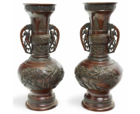 Pair of Japanese two-handled bronze vases, of baluster form with elongated neck, decorated with a raised pattern of birds and