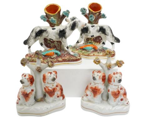 Two pairs of Staffordshire figures, the spill vases formed as two retrievers/hunting dogs against a tree trunk with game, on 