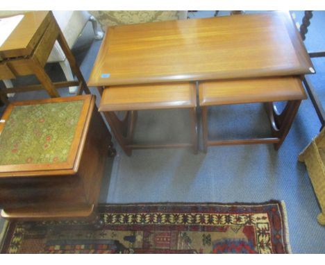 A G-plan teak nest of three tables, and a Victorian mahogany commode with inset tapestry panel to hinged top, fitted interior