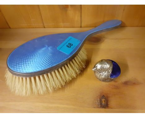 A white metal and blue velvet pin cushion in the form of a robin together with an early 20th Century silver and blue enamel b