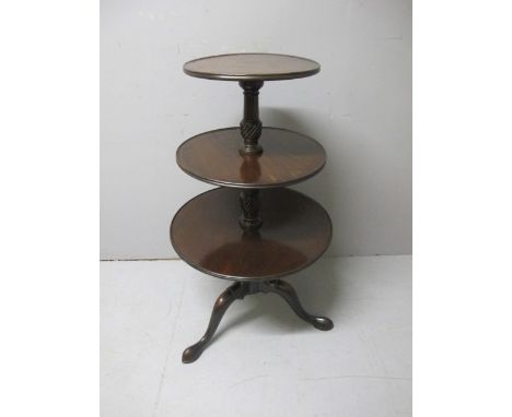 A GEORGIAN MAHOGANY THREE TIER DUMB WAITER each circular dish raised on a spiral twist column on tripod support with pad feet