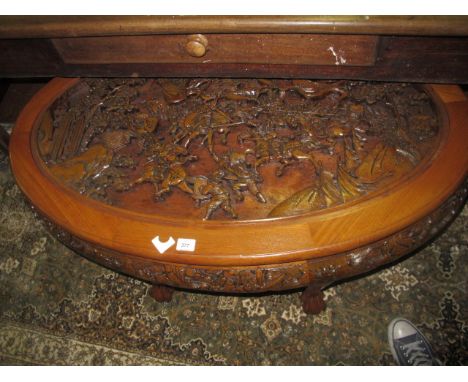 AN ORIENTAL HARDWOOD COFFEE TABLE of oval outline above a carved apron on cabriole legs with claw and ball feet 121cm x 71cm