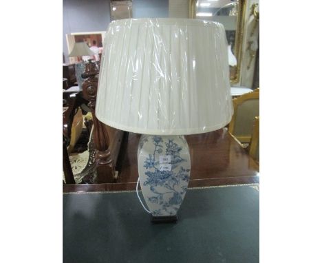 A PORCELAIN TABLE LAMP the white and blue ground decorated with flowerheads and foliage raised on a hardwood base with pleate