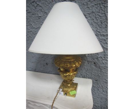 A GILT BRASS TABLE LAMP of urn form moulded in high relief with foliage 56cm (h)