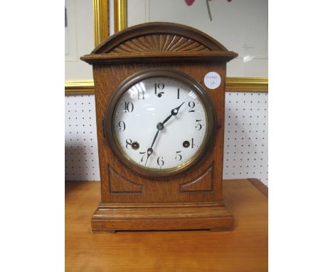 AN EDWARDIAN OAK CASE MANTLE CLOCK of rectangular arched form with enamel dial on block feet 34cm (h) x 23cm (w)