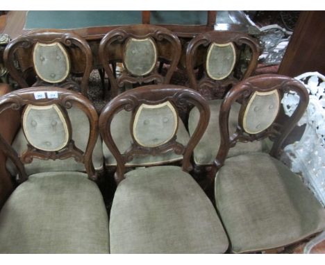 A SET OF SIX VICTORIAN OAK DINING CHAIRS each with a curved top rail above a button upholstered panel and seat on reeded and 