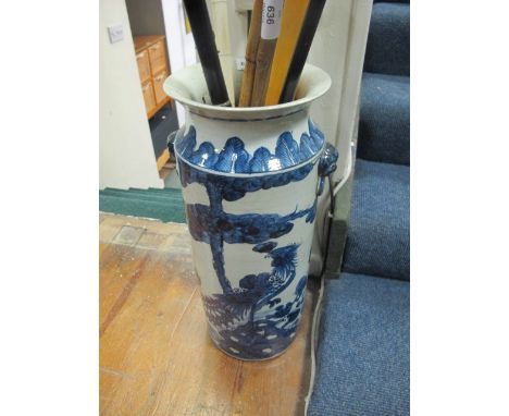 AN ORIENTAL STICK STAND the white and blue ground decorated with flowerheads and foliage with figural handles 56cm (h) x 23cm
