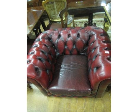 A WINE HIDE UPHOLSTERED LIBRARY CHAIR with deep button upholstered back and seat with roll over arms with loose cushion on ca