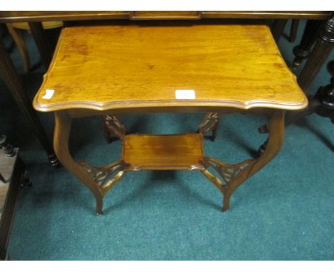 AN EDWARDIAN MAHOGANY OCCASIONAL TABLE the shaped moulded top raised on moulded supports joined by an under tier