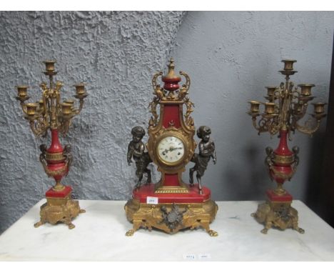 A THREE PIECE CLOCK SUITE the enamel dial within a shaped case surmounted with neo classical urn with pierced scroll handles 