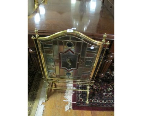 A BRASS LEAD GLASS AND COLOURED GLASS FIRESCREEN of rectangular arched form on splayed legs 81cm (h) x 55cm (w)