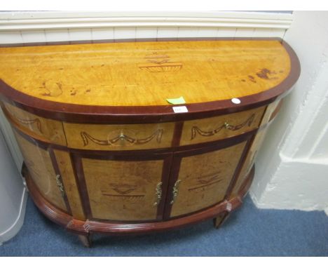 A GOOD WALNUT INLAID COMMODE of demi-lune outline the shaped moulded top above a frieze drawer and cupboards between moulded 