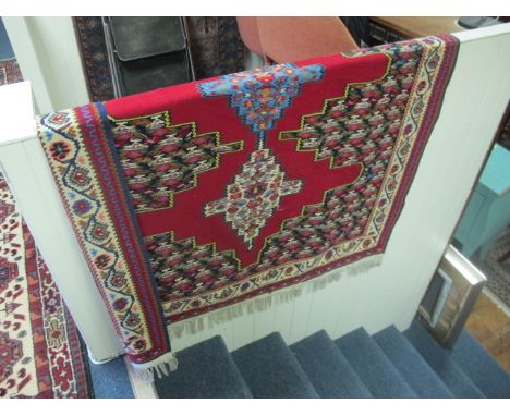 A PERSIAN KILIM WOOL RUG the wine and light blue ground with central serrated medallion with stylized birds within a three st