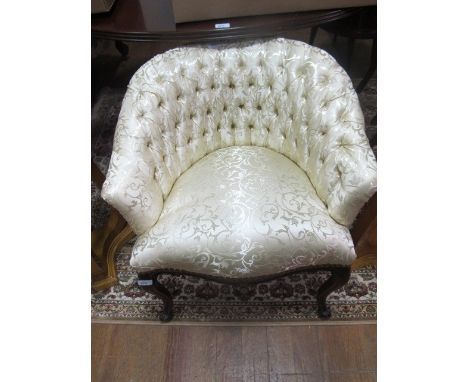 A MAHOGANY AND UPHOLSTERED TUB SHAPED BOUDOIR CHAIR with deep button upholstered back and seat on slender cabriole legs