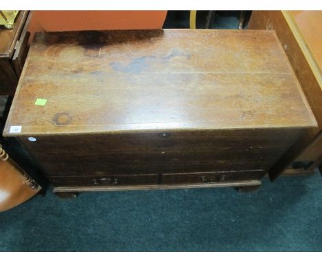 AN OAK TRUNK 19th Century the rectangular hinged top above a plain frieze containing two short drawers on bracket feet 67cm (