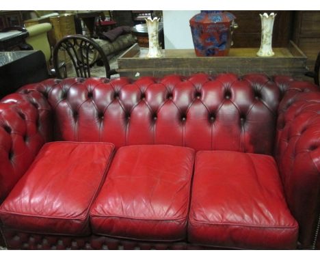 A WINE HIDE UPHOLSTERED LIBRARY COUCH with deep button upholstered back and seat with loose cushions 183cm wide