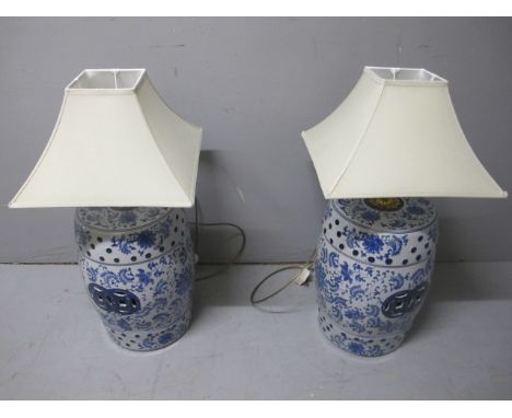 A PAIR OF ORIENTAL BLUE AND WHITE TABLE LAMPS each of barrel form the white and blue ground decorated with flowerheads and fo