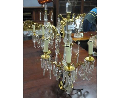 A PAIR OF GILT BRASS AND CUT GLASS TABLE CANDELABRAS the baluster column issuing four scroll arms with drip pans hung with fa