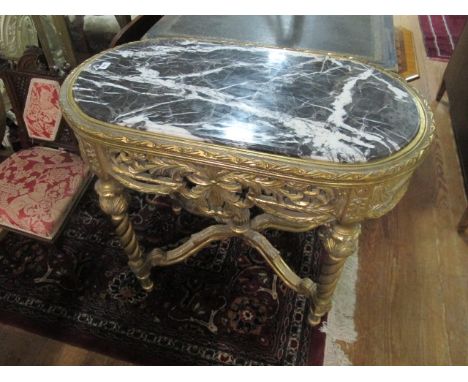 A CONTINENTAL GILTWOOD CENTRE TABLE of oval outline the shaped moulded top surmounted with a black vein marble top above a fo