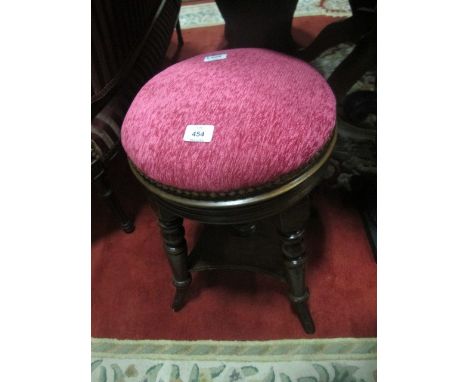 AN EDWARDIAN MAHOGANY STOOL the circular upholstered seat raised on turned legs joined by an under tier 53cm high