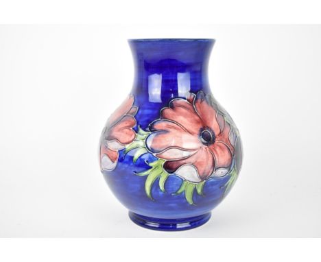 A William Moorcroft ceramic baluster vase in the 'anemone' pattern, with tubeline pink and purple flowers on a blue ground, t