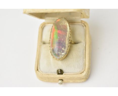 A yellow metal mounted impressive water opal cocktail ring, the oblong cabochon translucent stone set in a pierced mount, siz