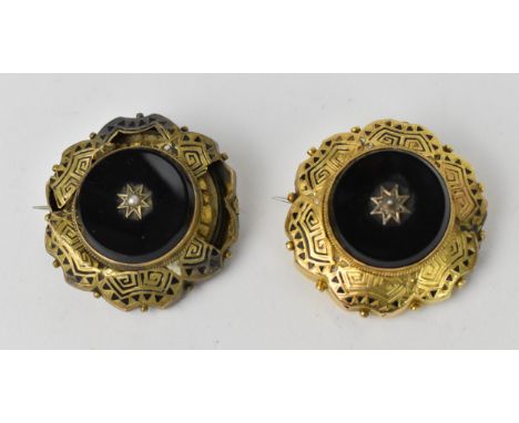 Two Victorian mourning brooches, each of circular form with Etruscan style enameling, centered with a split pearl in an onyx 