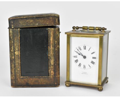 An early 20th century brass cased carriage clock, white enamel dial with Roman numerals and inscribed 'Selfridge London Made 