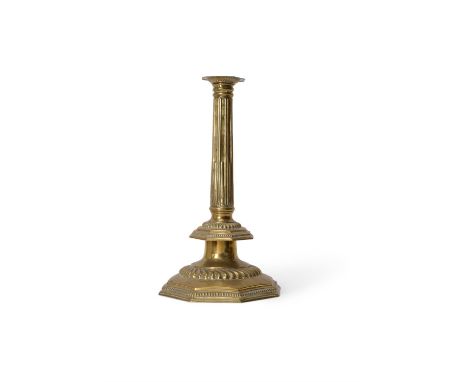 An impressive English repoussé brass columnar candlestick, late 17th century, the octagonal fluted and stop fluted stem with 