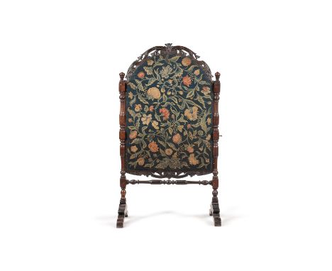 A William & Mary walnut and crewel work inset fire screen, circa 1690, the arched crewel work panel decorated with meandering