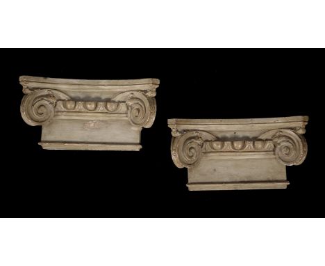 A pair of painted plaster Ionic order capitals, probably late 19th century, in the style of Brucciani, of slightly bowed outl