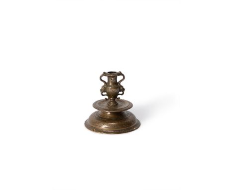A Venetian bronze alloy candlestick, late 16th/early 17th century and later drilled, the nozzle cast as a twin handled urn wi