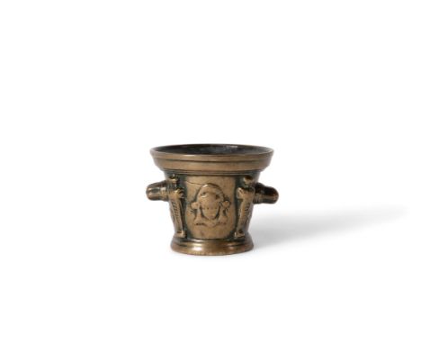 A French bronze mortar, late 16th or 17th century, cast with maidens' masks in relief divided by tapered buttresses, with twi