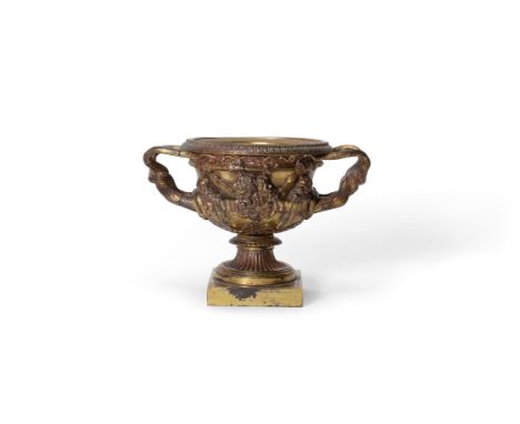 A gilt bronze model of the Warwick vase, 19th century, of typical twin handled form and relief cast with masks, 15cm high, 22