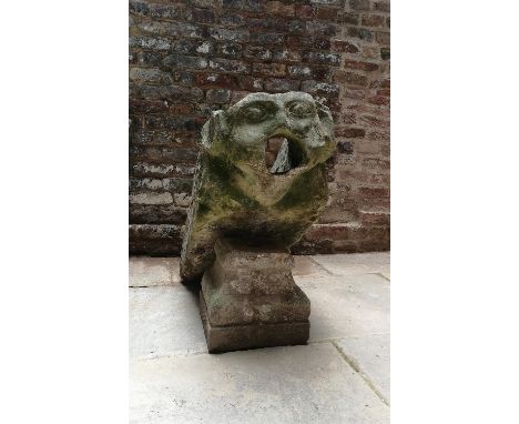 Two English sculpted limestone architectural masks or water spouts, late 14th century, one terminating in a grotesque mask wi