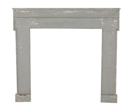 A grey painted wood fire surround, mid 18th century and later re-painted, the protruding mantel shelf above the moulded friez