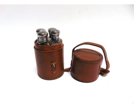A RIDER'S QUARTET DRINKING FLASK in a leather case, the four glass bottles with silver screw caps, London 1912, bottles 11cm 
