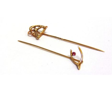 A STICK PIN OF RIDING INTEREST the stirrup and snaffle motif seed pearl set; with a wishbone stick pin