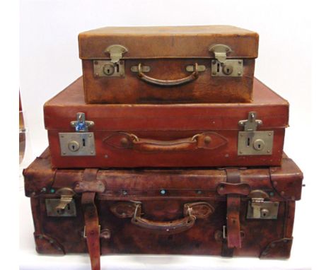 A LEATHER TRUNK with bound corners and straps, 72cms wide; and two other leather cases, the smallest with initials 'M.B', the