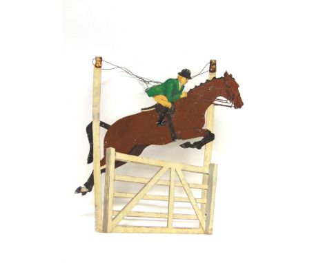 AN ALUMINIUM EQUESTRIAN OPENWORK SIGN depicting a lady in hunting dress on a bay horse jumping a five-bar gate, 64cm high, 58