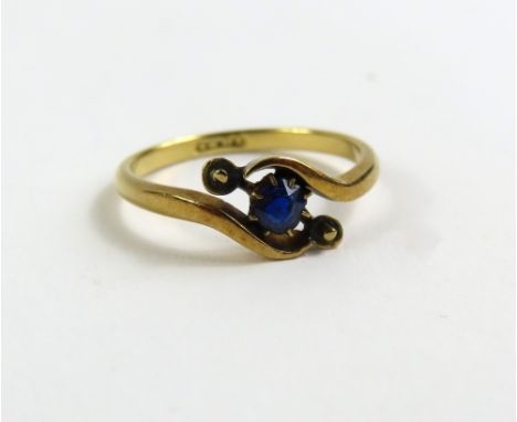 A twist set sapphire single stone ring, marked '18ct', finger size L 1/2, 2.1g gross 