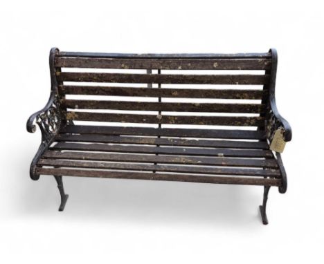 A weathered blacked painted wrought iron framed garden bench