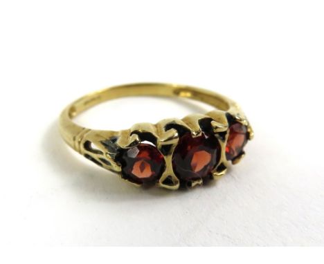 A 9ct gold garnet three stone ring, finger size Q, 2.1g gross