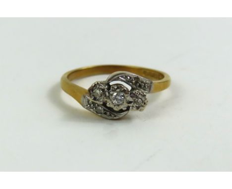 An 18ct gold three stone diamond twist ring with diamond set shoulders, finger size P, 3.6g gross